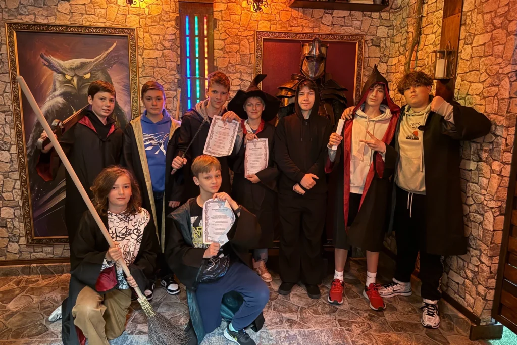Grupa chłopców w pelerynach po zakończeniu wyjścia klasowego do escape roomu.