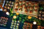 Mini burgery z pomidorkiem koktajlowym na wykałaczce, serwowane dla dzieci.
