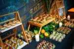 Stół pełen przekąsek: mini burgery, kanapeczki i croissanty w aranżacji eventowej.