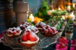 Tartaletki z malinami posypanymi cukrem pudrem, słodki element menu dziecięcego.