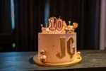 Tort urodzinowy z cyfrą 10 i złotymi dekoracjami, przygotowany na przyjęcie dziecięce.