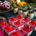 Kolorowe desery z musem śmietankowym i galaretką z truskawką na eleganckim stole, przygotowane na urodzinowe przyjęcie dla dorosłych